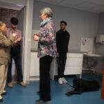 TP - Personnes discutant avec un chien-guide assis.