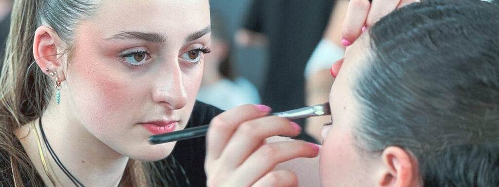 Nos élèves en salon appliquant du maquillage avec précision.